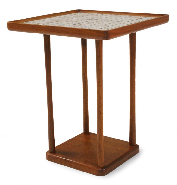 A charming occasional table comprising a square tabletop with square and round ceramic tiles set within a walnut frame with a gallery-like edge resting on four dowel legs all supported on a square, bull-nose edge walnut base. By Gordon Martz for