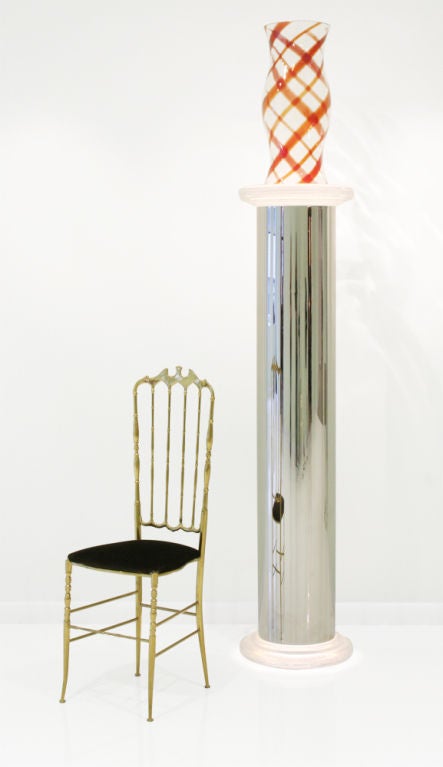 A tall pedestal in a classical column-form with a frosted Lucite capital and base, a polished chromed steel shaft, and an interior light that illuminates the Lucite top and base. By Luten, Clarey and Stern, Inc.. U.S.A., circa 1970.