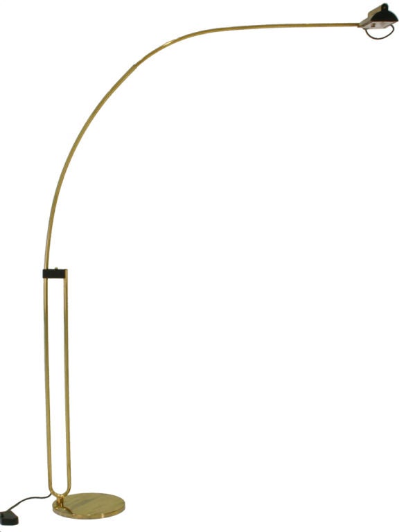 A very tall brass arching halogen floor lamp, swivel-mounted to a heavy round base with a triangular adjustable shade that can be positioned all along the pole, controlled with a foot switch. By Relco, Italian, circa 1970.