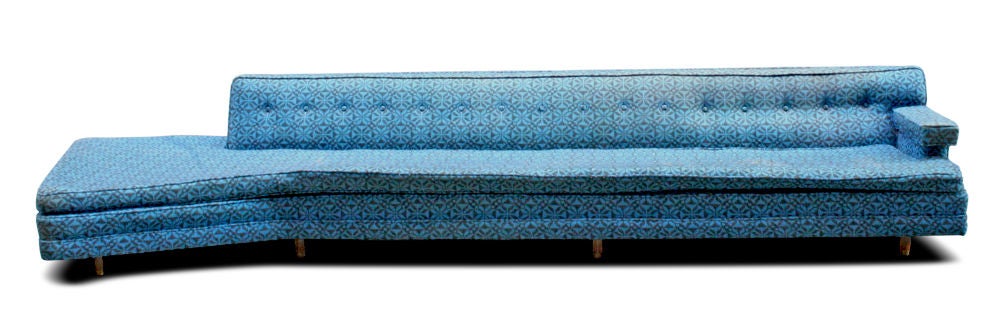 An ultra long sofa with an open angular ottoman and a rectilinear enclosed end with a cantilevered armrest, in original upholstery, all resting on hexagonal wood legs with brass sabots. By Harvey Probber. U.S.A., circa 1950. 
Measurement: 13 foot