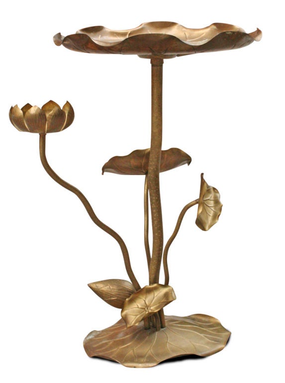 A petite table in the form of a lotus blossom with several stems and flowers, each with engraved and embossed detailing.  Stamped to the base 