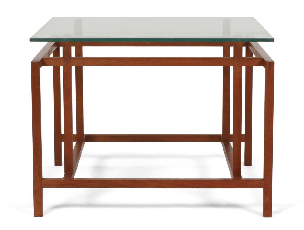 A pair of square end tables with glass tops that fit the exact proportions of the elegantly engineered structures with tongue and groove joinery, nicely rendered in teak. By Komfort, Danish, circa 1960.