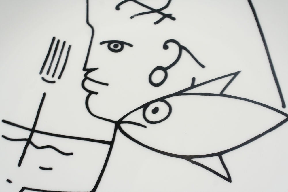 A hand painted plate of a fisherman. Signed 'Jean Cocteau' to the front, stamped 'Limoges France' to the back. By Jean Cocteau for Limoges.  French, circa 1950.