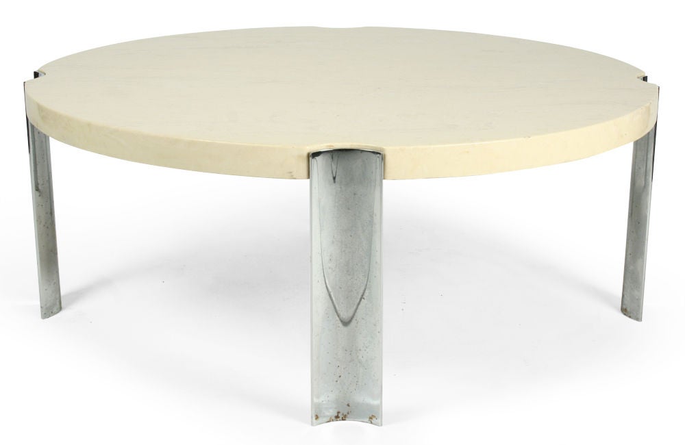 A sleek cocktail table comprising a circular top of marbelized composite supported on four curved legs of chrome-plated steel that are inset into the top. American, circa 1970.