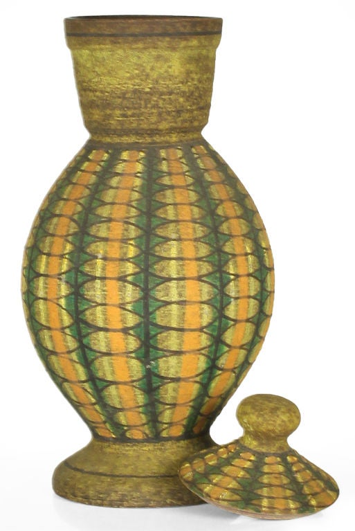 A sweet lidded ceramic vase in a classical urn form decorated with a geometric pattern in green, orange and black on yellow ground. By Aldo Londi for Bitossi. Distributed by Raymor. Italy, circa 1950.