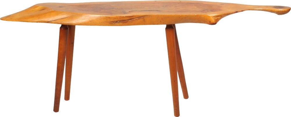 A wonderful American Studio cocktail table comprising a long and narrow, bias sliced, free edge slab walnut top raised on turned legs. Carved signature of artist, location and date. [Roy Sheldon Marlboro, VT. 1963] U.S.A., 1963.