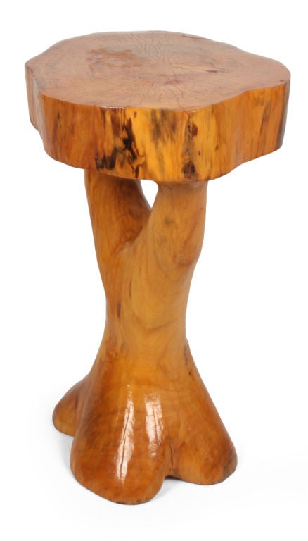 A Hippie Chic organic table comprising a thick slab of wood for the top supported on a wood base shaped like the root of a tree. In the manner of J.B. Blunk. U.S.A., circa 1960.