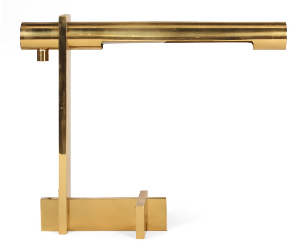 A chic desk lamp with an adjustable pivoting tubular shade and integral dimmer switch supported on a solid brass bar cross base. With manufacturer's label to base.  By Casella Lighting.  American, circa 1970. Two available.