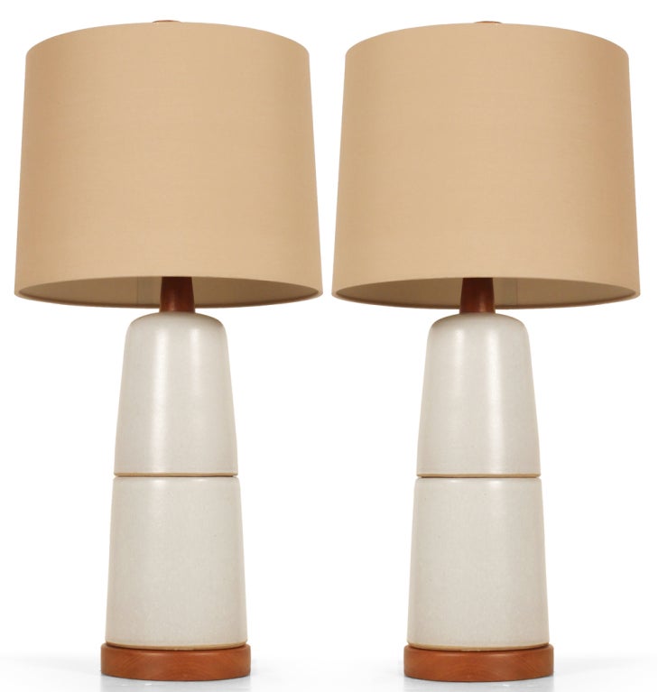 A pair of stone white glaze ceramic stacked double cone lamps with walnut bases, stems and finials. By Gordon Martz for Marshall Studios. American, circa 1950.

 