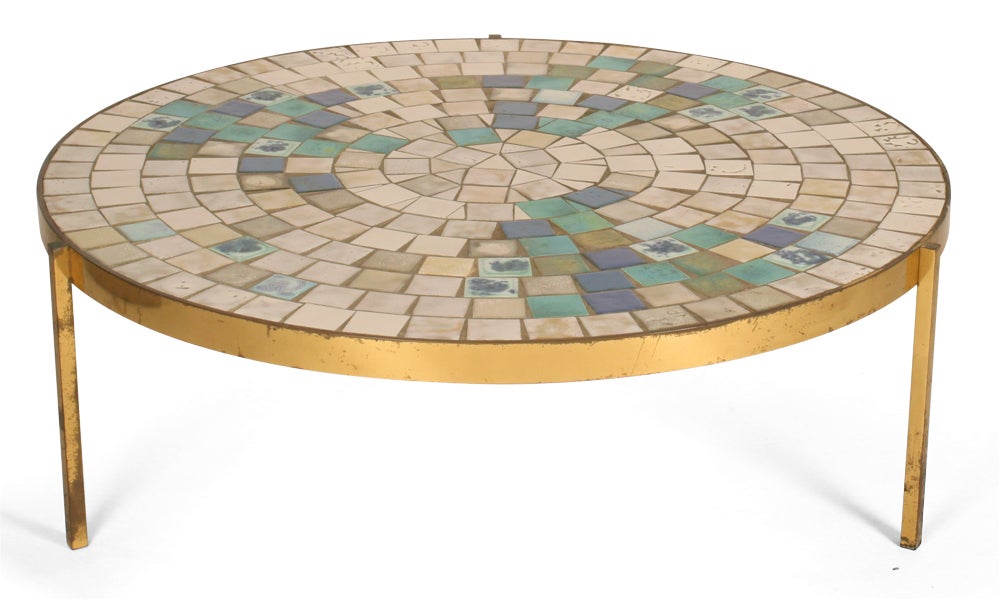 A fantastic cocktail table in a circular form with a heavy bronze frame and a ceramic tiled top in cream, blue, and green colors.  By Mosaic House.  American, circa 1960s.

Please call gallery for details, availability and item location.
