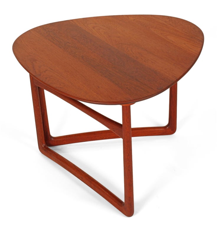 A triangular shaped top convertible occasional table in oiled solid teak and specialized brass fittings. The gate leg pivots inward allowing the table top to fold down flat for easy storage while not in use. Model no. fd 18/57. Designed by Peter