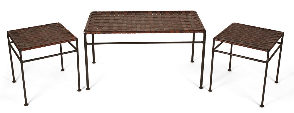 A wonderful set of nesting tables comprising a rectangular table and a pair of smaller square tables each with woven saddle leather strap tops on wrought iron frames.  After Swift and Monell. American, circa 1950.
