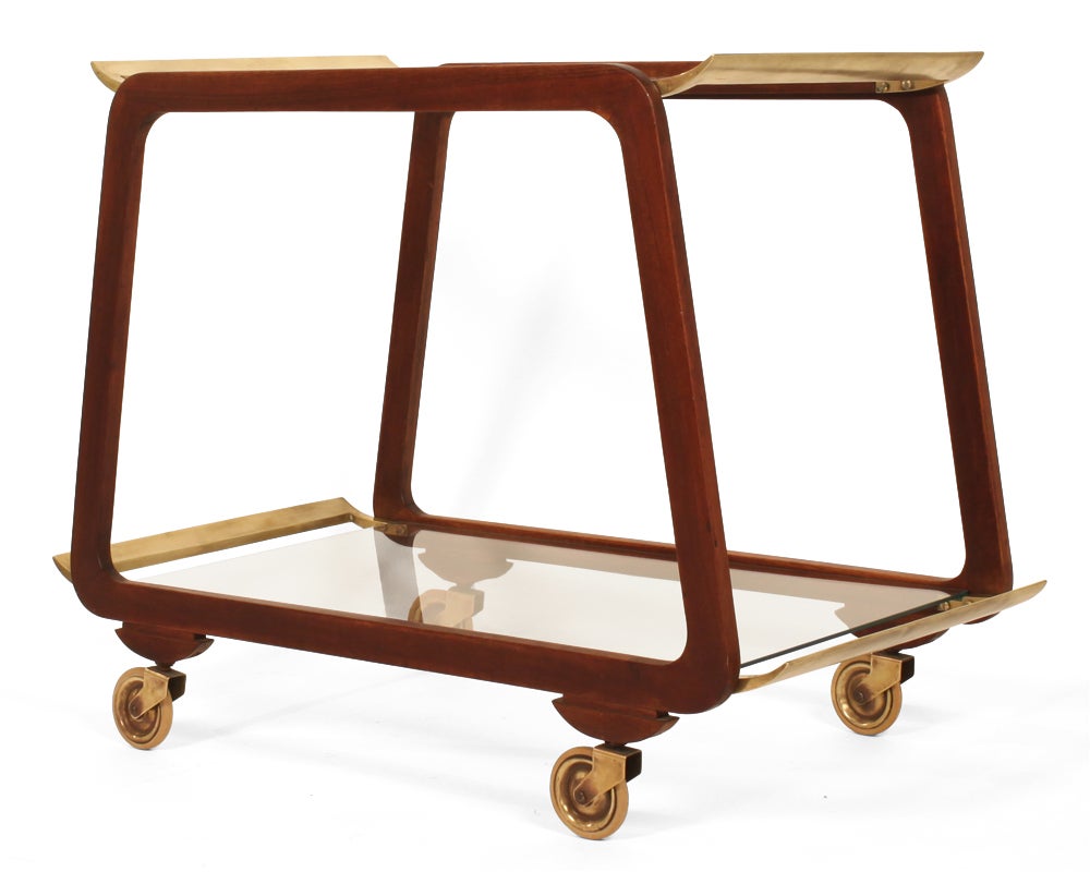 A beautiful serving trolley comprising a pair of walnut Silhouette frames with solid brass wing handles and removable glass shelves. Austria, circa 1960. [DUF0219] [DUF0220]