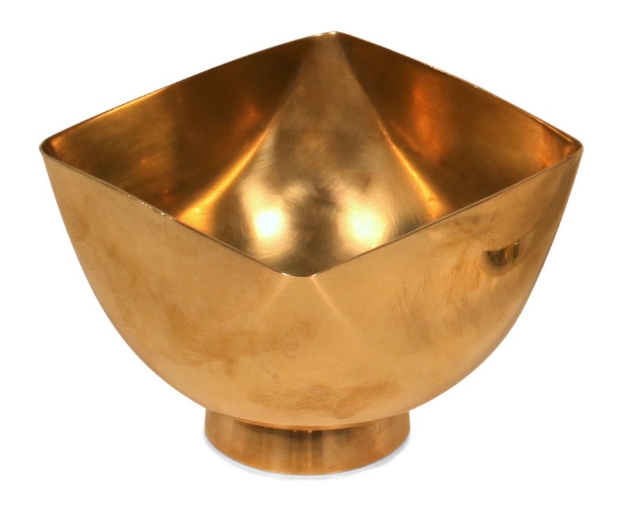 A candy dish in brass with a square soft cornered top and rounded bottom, the whole resting on a circular foot. Signed to the base.  By Ward Bennett. American, circa 1970.