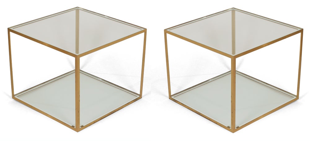 A refined pair of occasional tables comprising an open cube form frame in brass with two glass panes: one for the top and the other for the base.  After Maison Jansen. French, circa 1970.