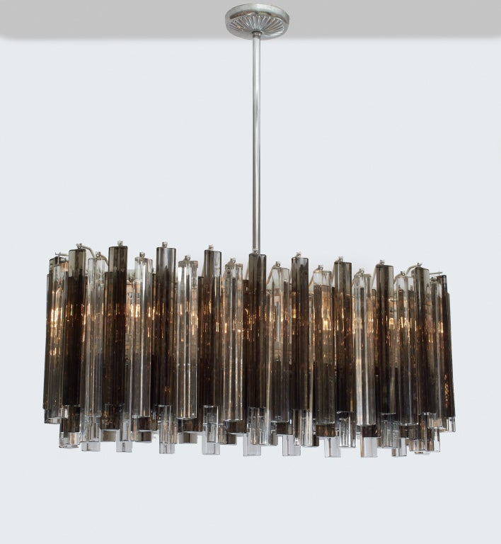 A beautiful chandelier with Murano glass prism elements arrayed in a race track form; each triangular crystal rod alternating from clear to smoked glass. By Venini. Italian, circa 1960.