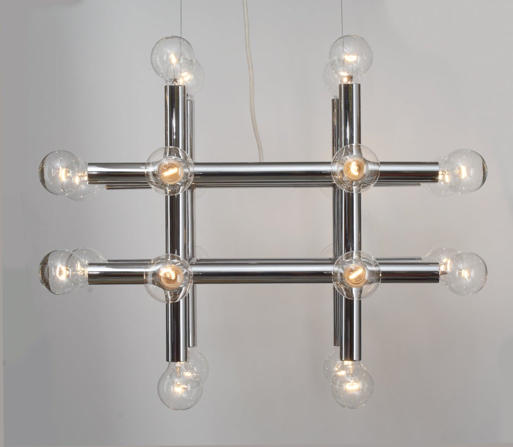 A Space Age chandelier comprising eight chrome steel tube arms in a 'tic tac toe' formation, each with a bulb at both ends. By Trix and Robert Haussmann for Swiss Lamps International. Switzerland, circa 1960. 