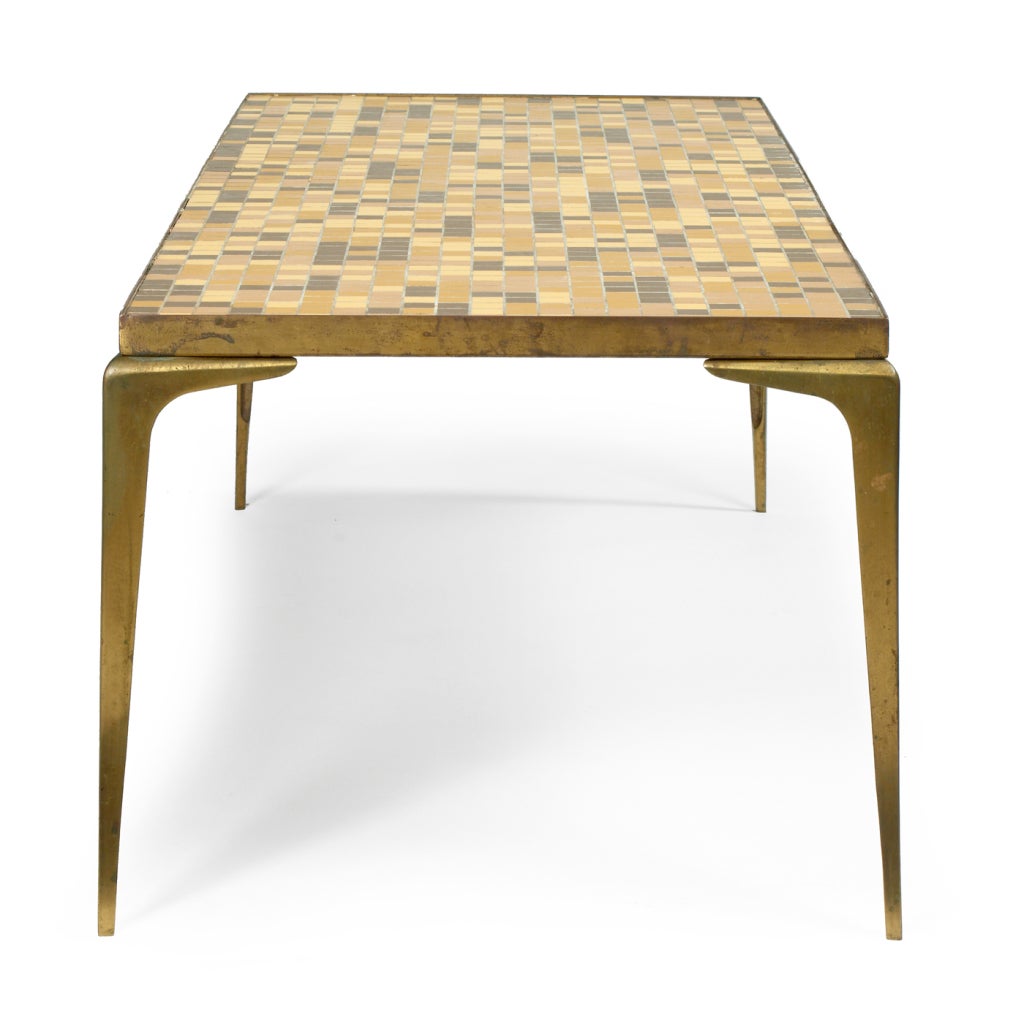 A Mid-Century Modern cocktail table comprising a rectangular brass framed top inlaid with mosaic tiles supported on tapered brass legs. Retailed by G. Fox & Company of Hartford, CT.  Italian, circa 1950.
