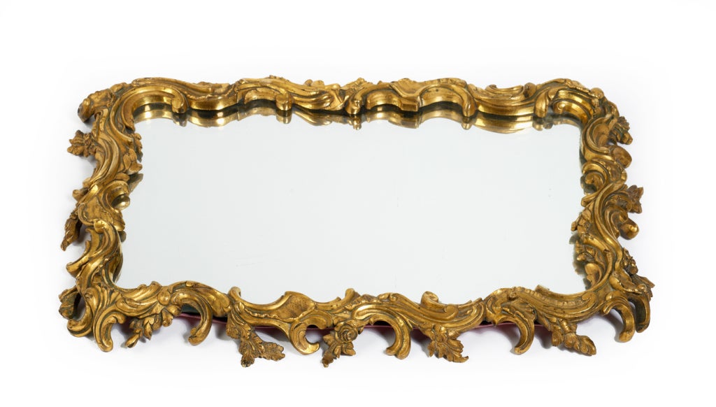 An ornate and heavy vanity tray comprising a mirrored surface within a gilt bronze, garland frame, French, circa 1890.
