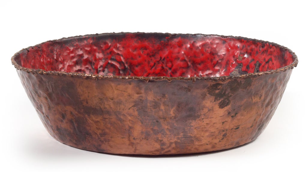 A fantastic torch cut and hand-hammered copper bowl with an apple red enameled interior and an earthy patina. Marked 