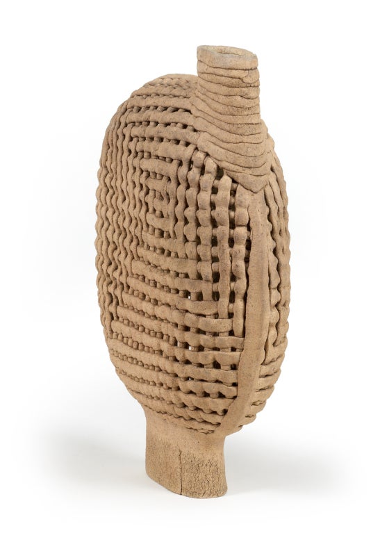 A superb handcrafted vessel composed of basket woven strips of stoneware, with an oval neck and raised on an tall oval foot. By Allester Dillon, American, circa 1980.