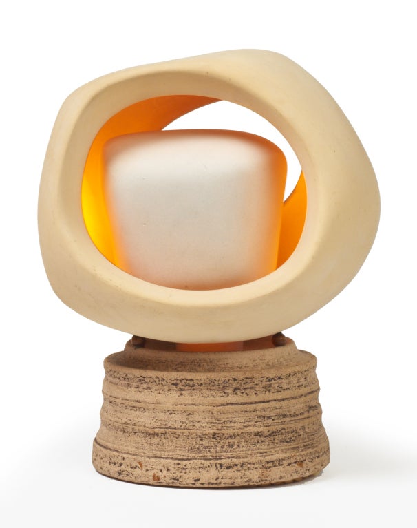 A nightlight with a pivoting inner and outer sculpted bisque shade assembly resting on a round stoneware base. By Sculplight. U.S.A., circa 1972.

