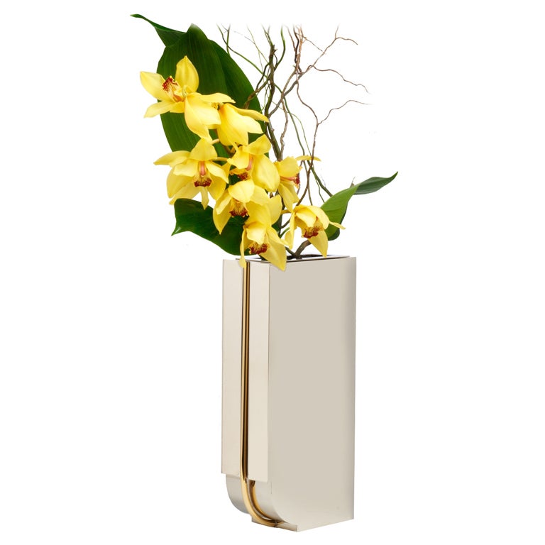 A bold 'Art Deco' styled metal vase in mirror polished chrome steel with brass tube trim. By Montagnani for Lorin Marsh. Italy, circa 1980.

  