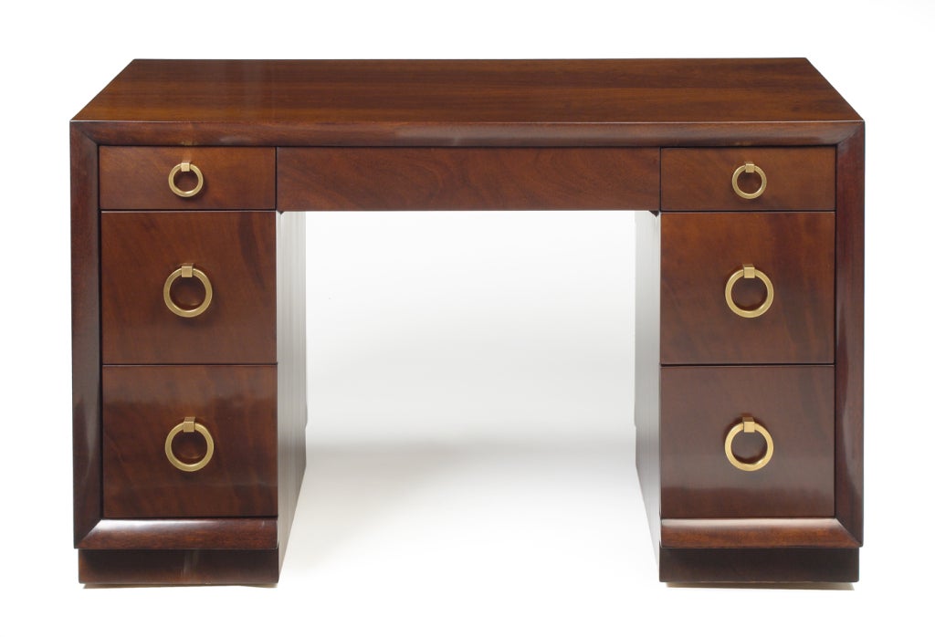 A classy kneehole desk with round brass 'door knocker' drawer pulls, three drawers in each pedestal and a center drawer located under the top surface. Mod. no. 317. By T.H. Robsjohn-Gibbings and produced by Widdicomb Furniture Company. U.S.A., circa