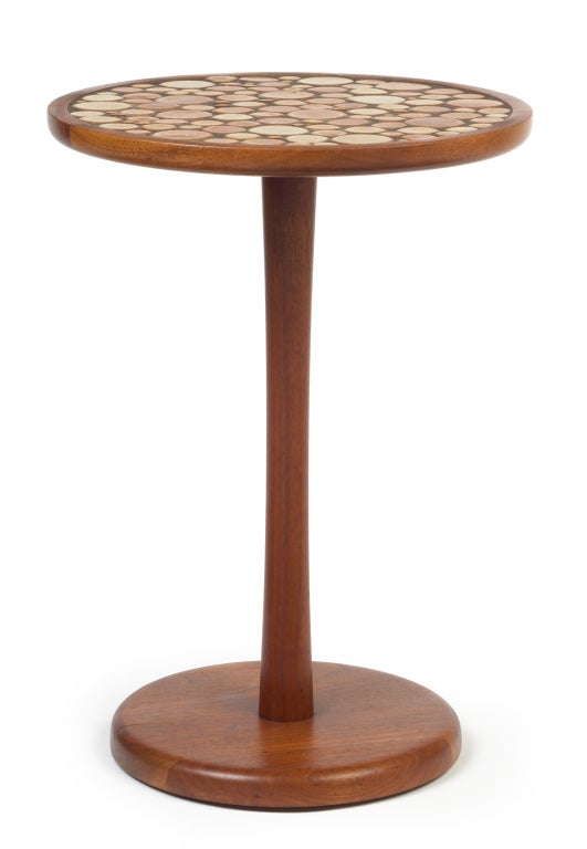 Walnut pedestal occasional table with ceramic tile coin composition by Gordon Martz for Marshall Studios. Glossy brick red and tan ceramic tiles of varying diameters all framed in a round walnut band. American, circa 1950. Literature: Marshall