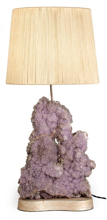 A beautiful table lamp with a natural Amethyst quartz specimen mounted on a silver leaf wood base. The vintage string shade is original to the lamp. Quartz specimen measures 19 3/4