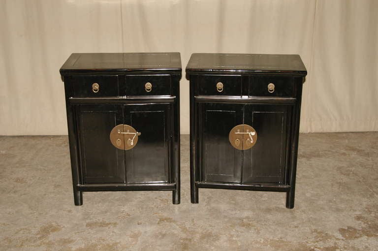 A pair of elegant and fine black lacquer chests, two drawers and a pair of doors with brass fitting. Beautiful form, lines and colors.