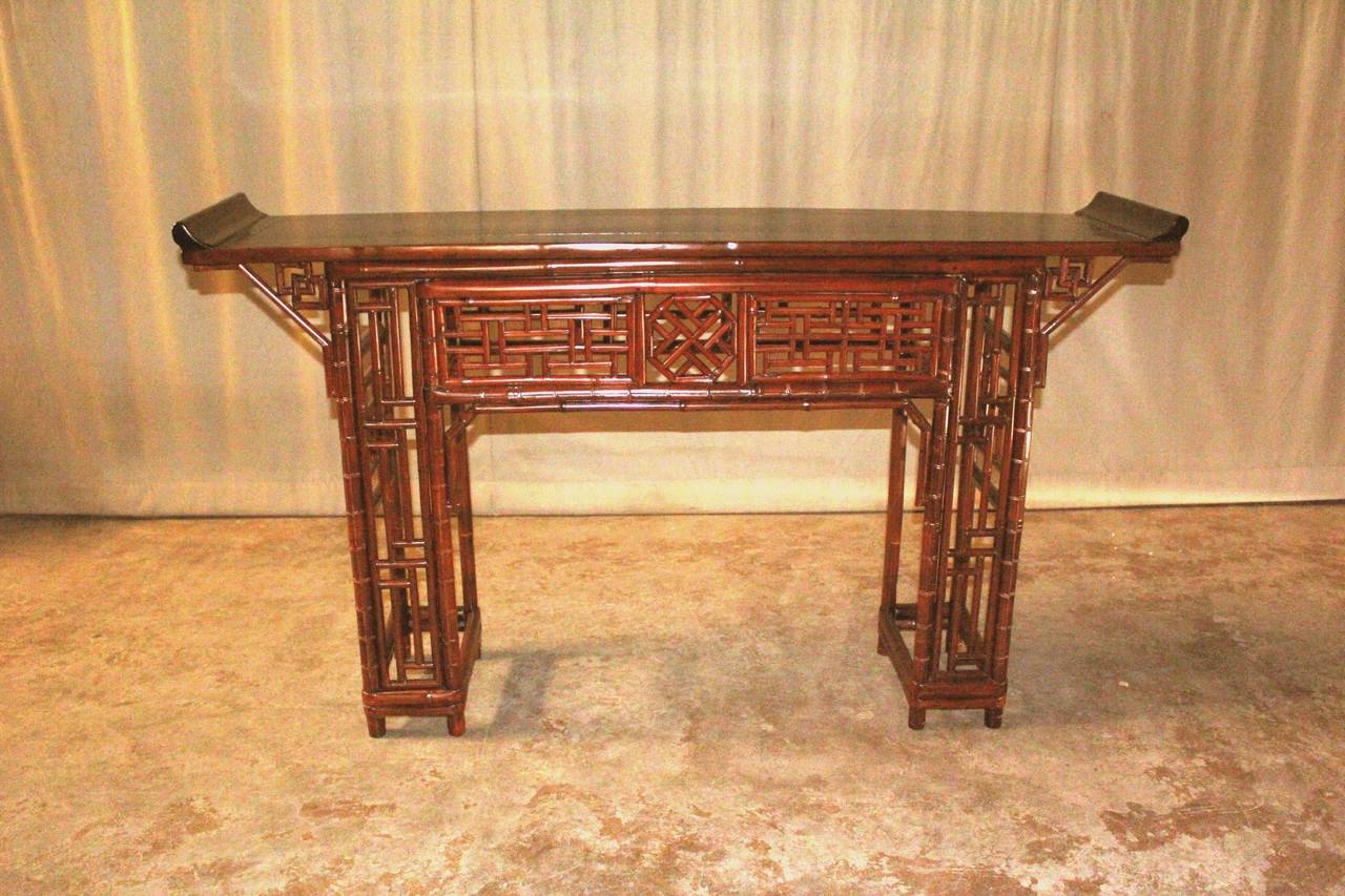 A refined and elegant bamboo console table, black lacquered top ended in everted flanges, Fine bamboo lattice fret work on the apron and legs, beautiful color, form and lines.  We carry fine quality furniture with elegant finished and has been