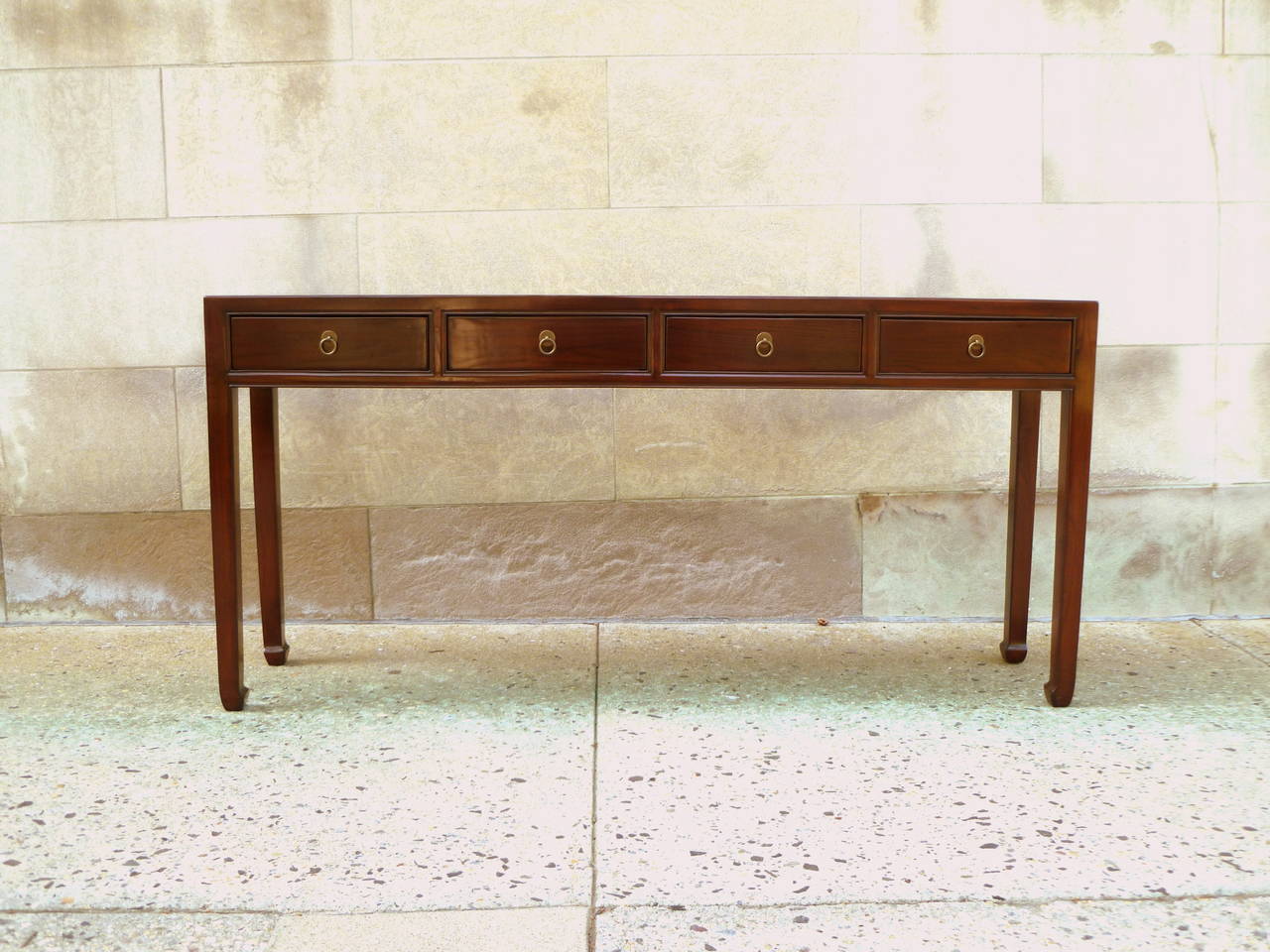 A refined and elegant ju mu woodconsole table with four drawers, brass ring pulls, beautiful color, form and lines.