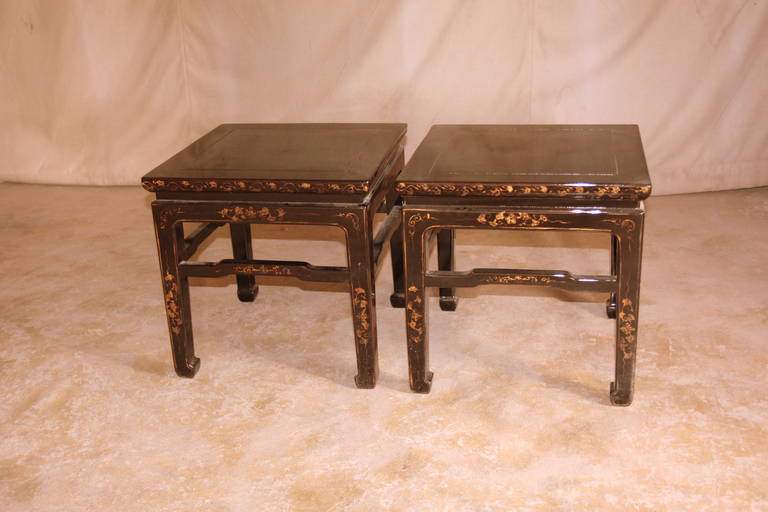 A pair of simple and refined black lacquer square end tables with hand-painted floral motif in gold gilt, beautiful color, form and lines.