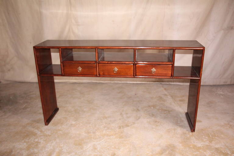 A refine and elegant Jumu console table with shelves and three drawers with panels legs, elegant form and lines.