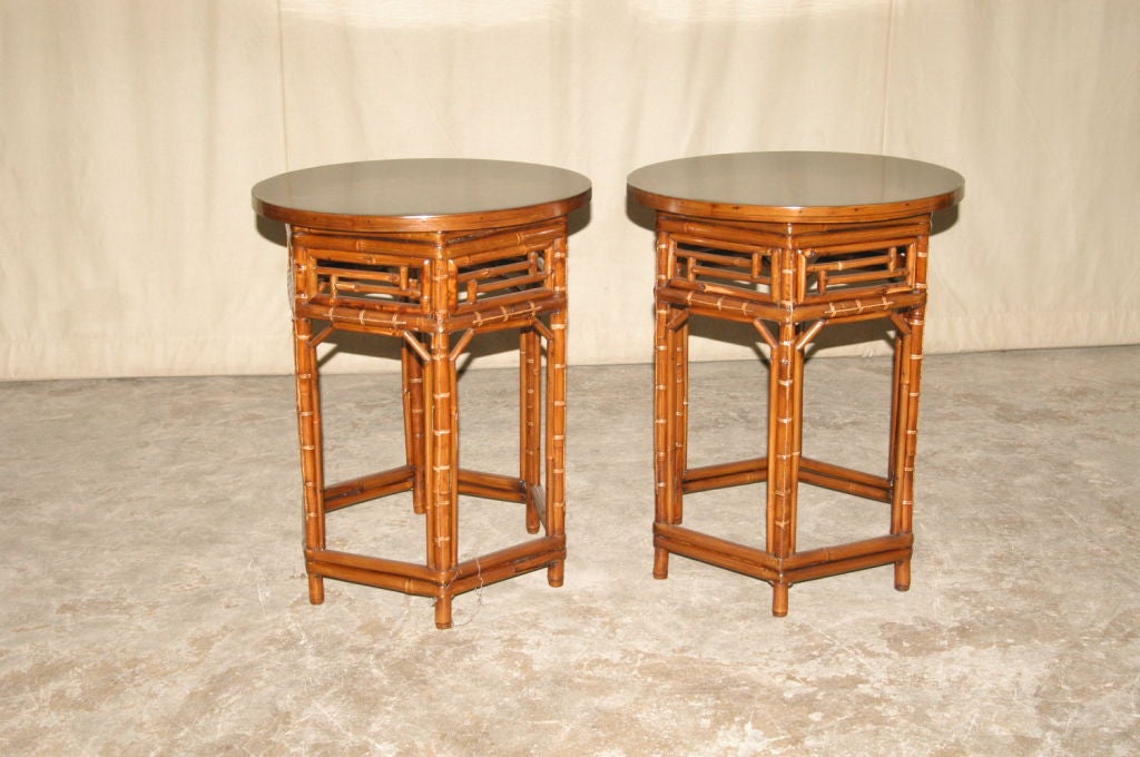 A pair of elegant bamboo round end tables with black lacquer tops, fine lattice fretwork, beautiful color, form and lines.