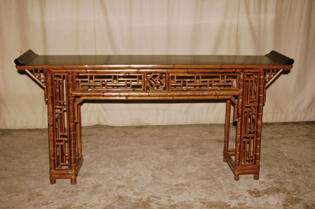 A very refined and elegant bamboo altar table , black lacquered top ended in everted flanges, fine lattice fret work on the apron and legs. View our website at: www.greenwichorientalantiques.com for additional altar table selections.