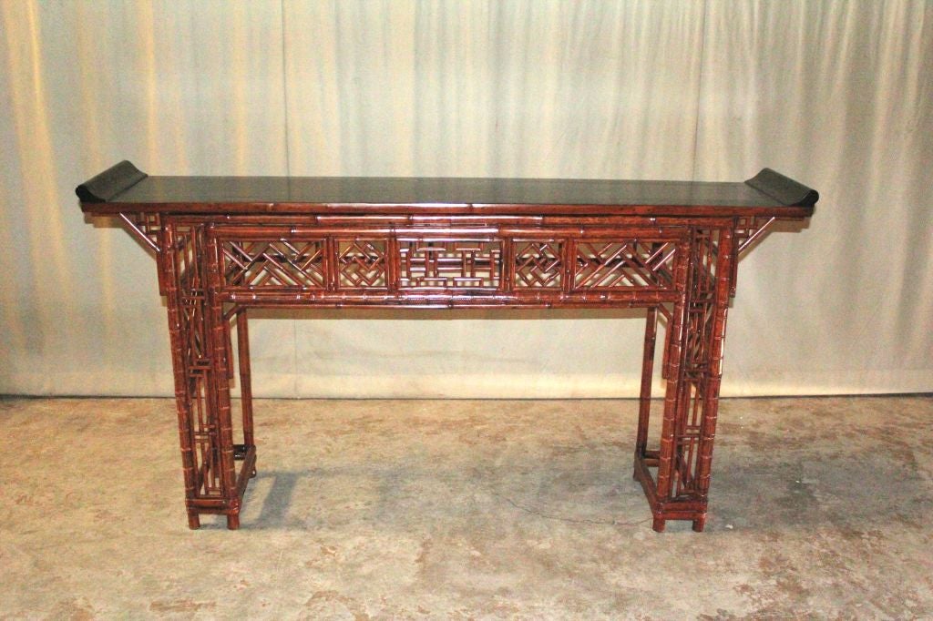 refined and elegant bamboo console table , black lacquered top ended in everted flanges, fine lattice fret work on the apron and legs, beautiful color, form and lines. View our website at: www.greenwichorientalantiques.com for additional console