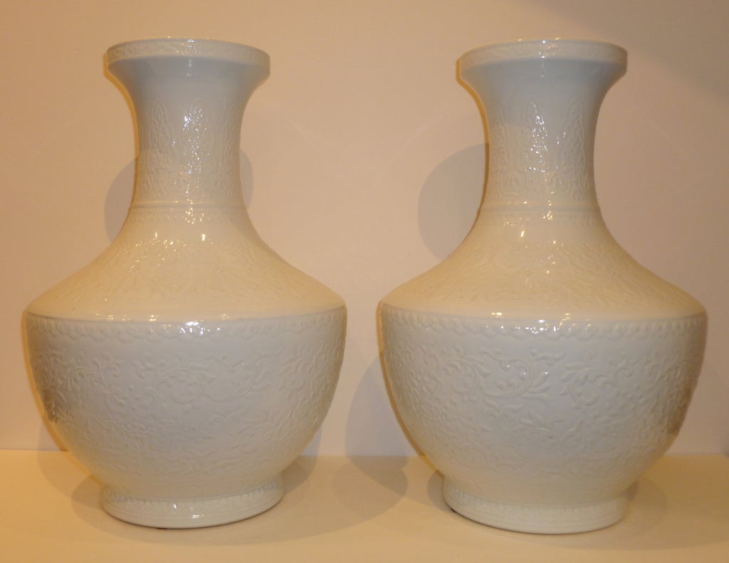 A pair of refined and elegant white porcelain vases with under glaze floral motif. Beautiful color, form and lines.