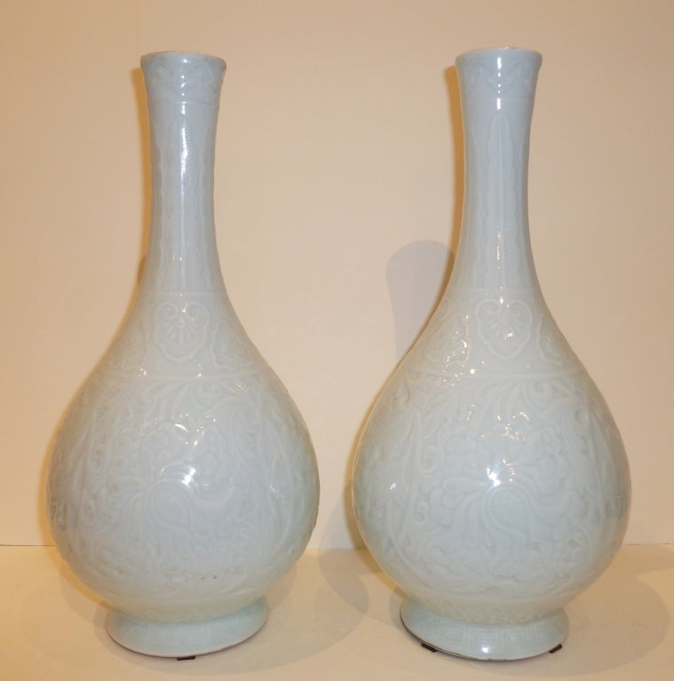 Une paire de vases simples et élégants en porcelaine monochrome, avec un fin motif floral sous glaçure. Belle couleur, forme et lignes.
