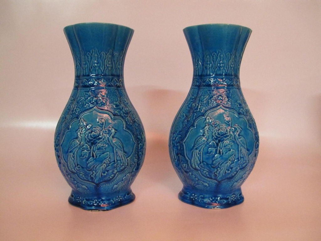 Pair of blue chinese vases depicting pheasants and flora in relief.