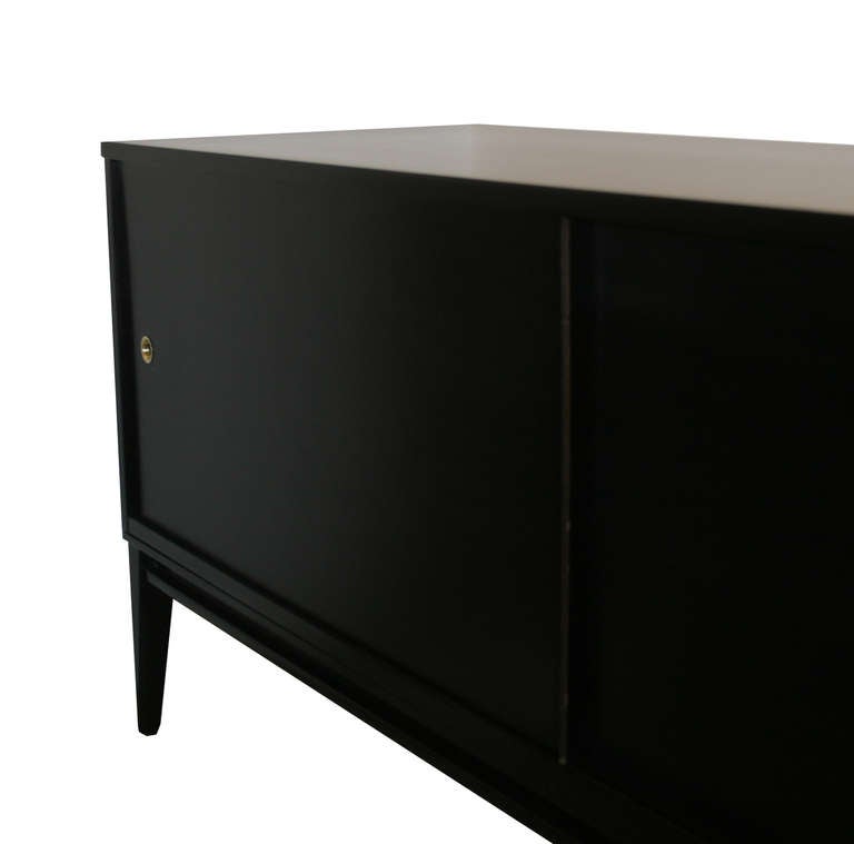 Paul McCobb Low Profile Planner Group sliding door console.Fully restored in a hand rubbed black satin lacquer finish with polished brass finger pulls.Solid maple construction through, with 2 adjustable shelves on the interior.

This item is