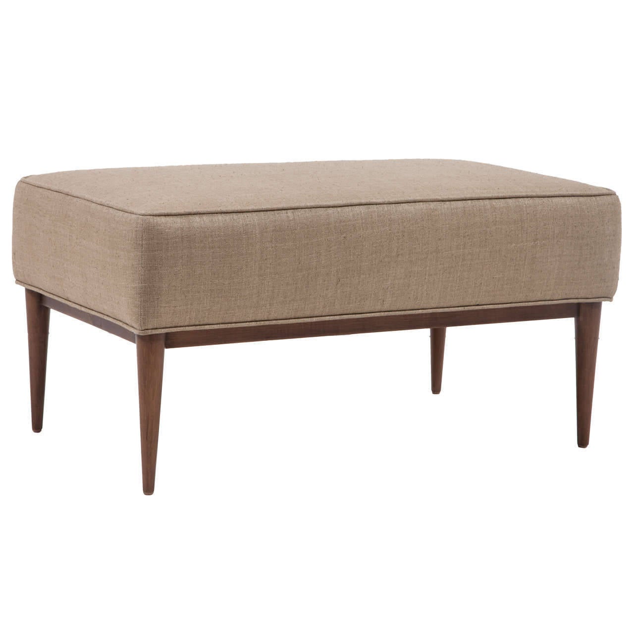 Lindy ottoman on solid turned leg base.

COM requirements: 2 yards.
5% up-charge for contrasting fabrics and or welting. 
COL requirements:40 sq. feet.
 5% percentage up-charge for all COL or exotic materials.

Custom orders have a lead time