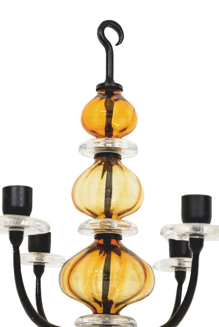 Hanging six arm candelabra by Swedish designer Erik Hoglund. Manufactured by Boda Nova glassworks and Axel Strömberg Ironworks, Sweden. Wrought iron structure with blown amber glass details.
