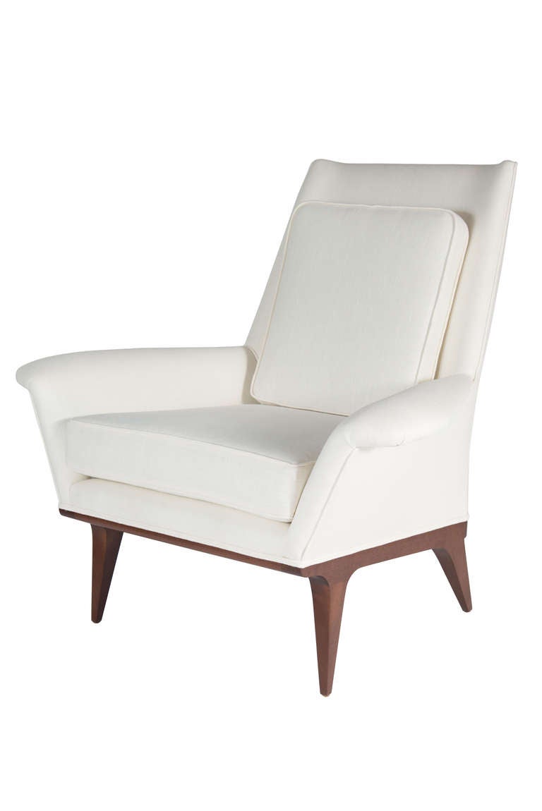 Mn originals low wing armchair on solid sculpted base. Low wide winged arm contrasted by tall slender back with loose natural down feather seat cushion.

Measures: Seat height 18.5