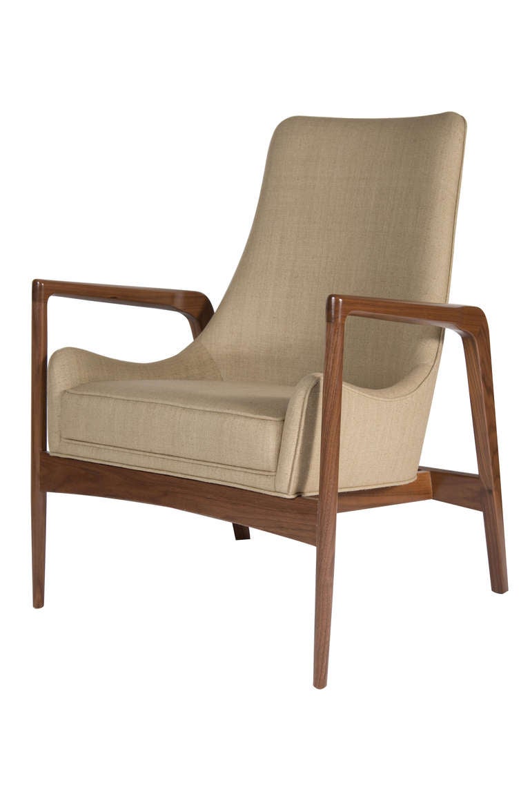 Solid walnut sculpted arm club chair. Sculptural profile upholstered one-piece construction that is integrated within the solid walnut framework. Natural finish on solid walnut frames with cotton linen upholstery.
Seat height-17.5".
Seat