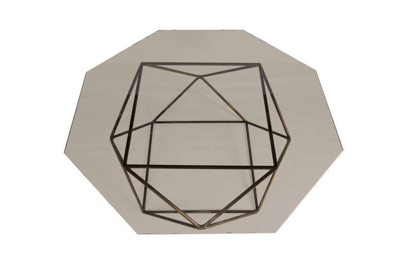Bronzed glass octagon cocktail table on bronze patina iron rod sculptural base.

Custom orders have a lead time of 10-12 weeks FOB NYC. Lead time contingent upon selection of finishes, approval of shop drawings (if applicable), and receipt COM (if