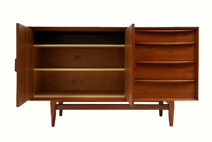 1960'd Danish modern console by Falster. Active grain teak veneer with solid teak detailing throughout, and natural birch interior.4 drawer and door exterior with adjustable shelf interior.Piece is finished on all 4 sides in the same teak veneer