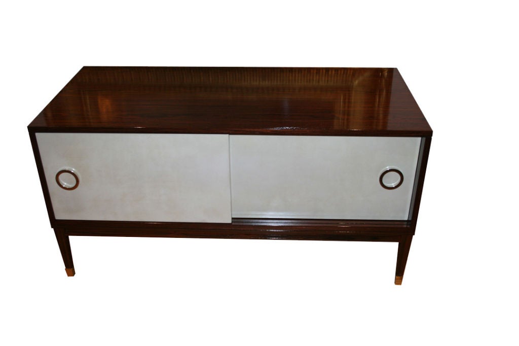 Rosewood console with natural parchment sliding doors detailed with nickel ring hardware and sabots.
Sabots shown not included in list price.

Custom orders have a lead time of 10-12 weeks FOB NYC. Lead time contingent upon selection of finishes,