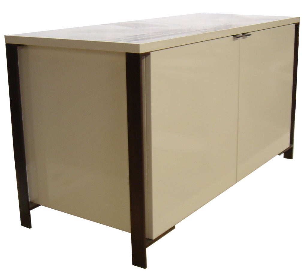 Mn Originals two-door lacquered media/bar cabinet detailed with bronze flat bar frame base. 

Custom orders have a lead time of 10-12 weeks FOB NYC. Lead time contingent upon selection of finishes, approval of shop drawings (if applicable) and